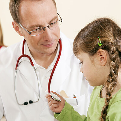Arzt untersucht ein Mädchen im Kindergartenalter