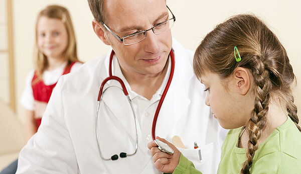 Arzt untersucht ein Mädchen im Kindergartenalter