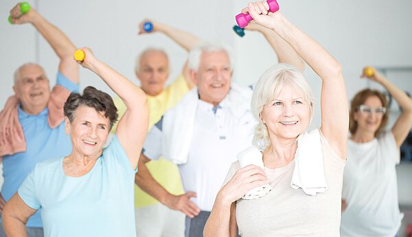 Eine Gruppe älterer Menschen trainiert mit kleinen Hanteln