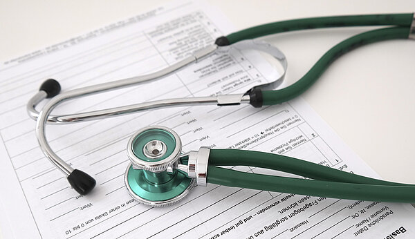 Ein Stethoskop liegt auf einem Formular