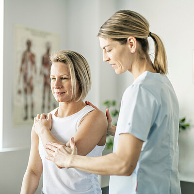 Eine Frau führt mit einer anderen Frau Übungen durch