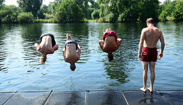 Jugendliche machen Salto in den See