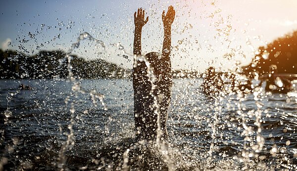 Personen baden in einem See in der Dämmerung