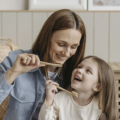 Eine Frau und ein kleines Mädchen putzen sich die Zähne